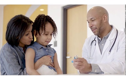 A photograph of a woman and child speaking to a male doctor, who is holding an inhaler