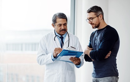 Doctor points out details on a chart to a concerned-looking patient
