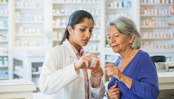 a pharmacist assisting and older woman with her medication